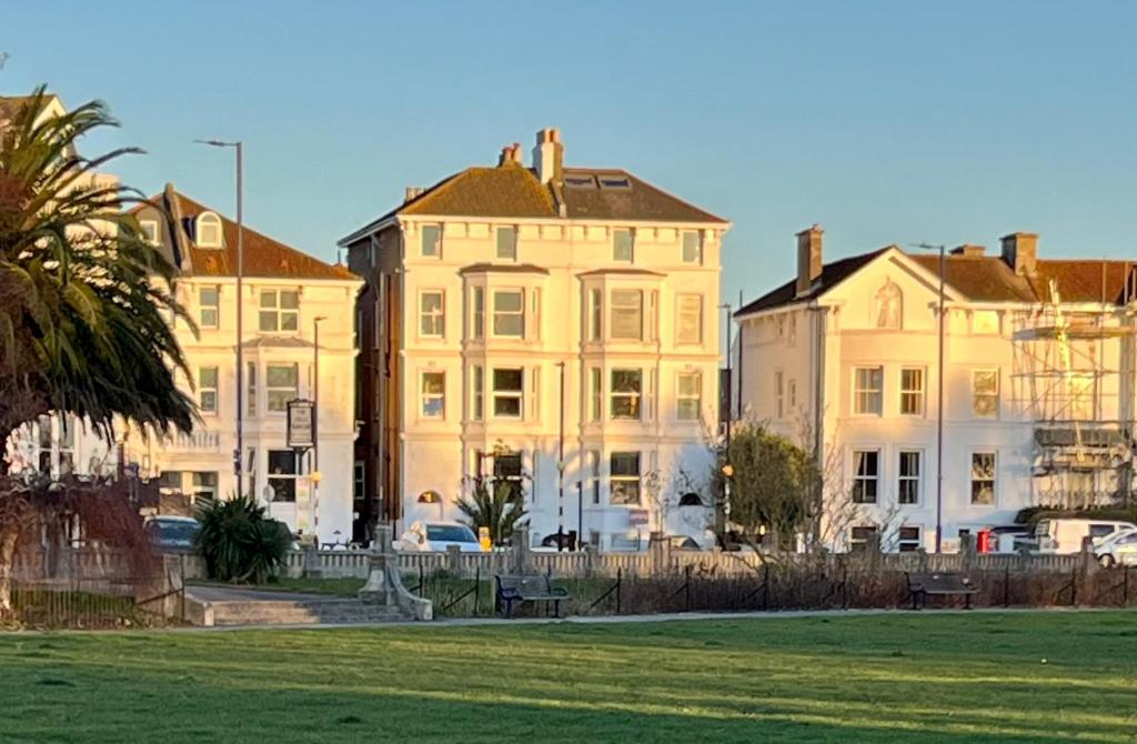 a large white building with cars parked in front of it at Southsea, Portsmouth - Two Bedroom Apartment - Newly Refurbished Throughout - Treetop Sea Views in Portsmouth