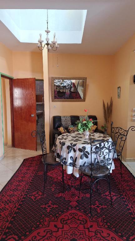 a dining room with a table and chairs on a rug at Jalila House in Aourir