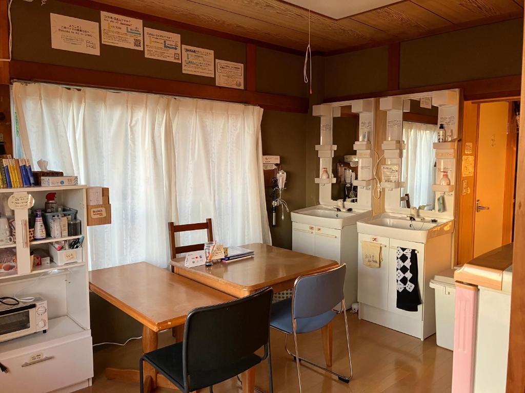 a kitchen with a table and chairs and a sink at 二段ベッドの宿青と白 in Aki