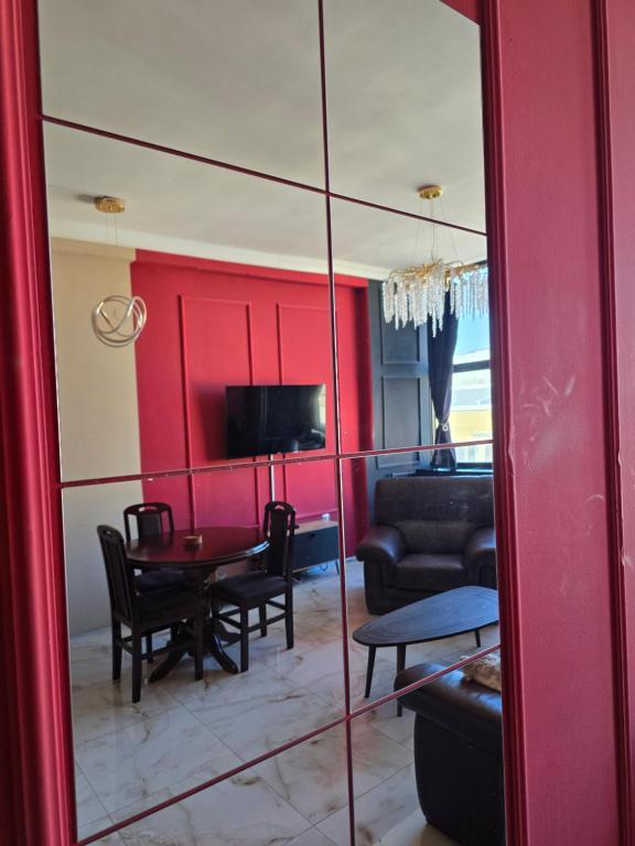 sala de estar con pared roja y espejo en Red Diamond, en Niš