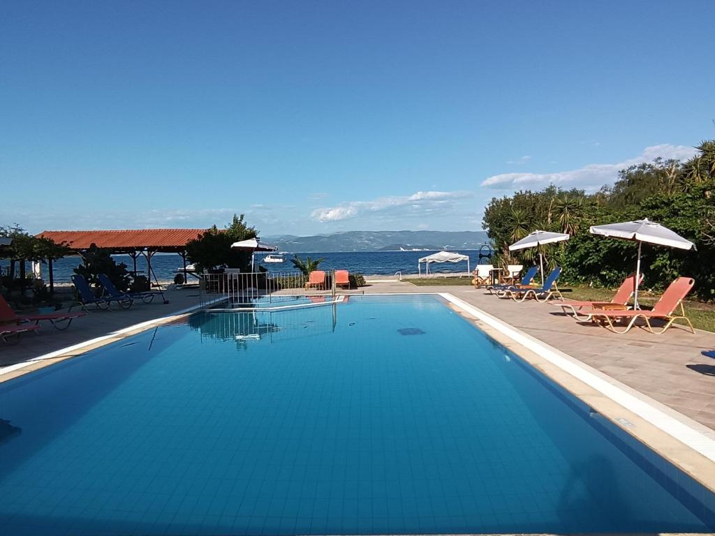 a swimming pool with a view of the ocean at Sofia Beach Apartments in Kavos