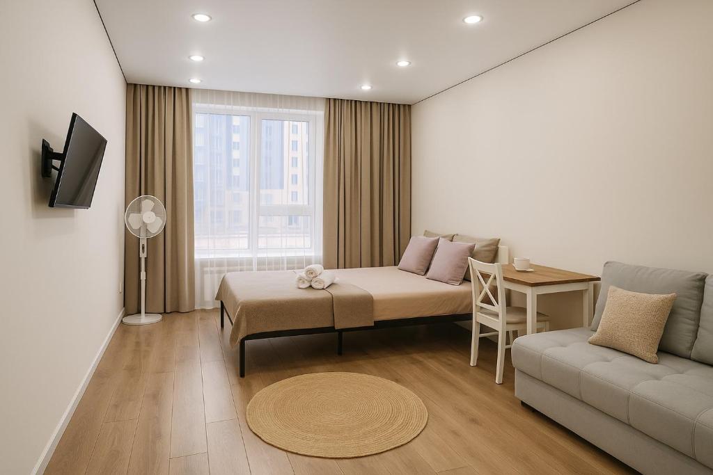 een woonkamer met een bank en een tafel bij ЖК Атамура in Promyshlennyy