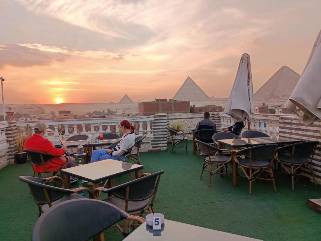 a group of people sitting at tables on a roof at Pyramids star of Khafre in Cairo