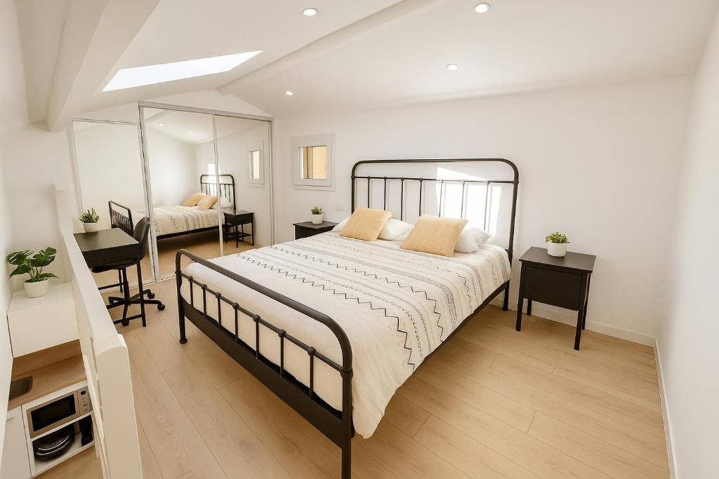 a bedroom with a large bed and a mirror at Le Nily Provence, douceur & vue d'exception in Sainte-Tulle