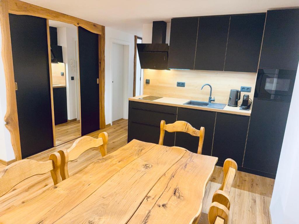 a kitchen with a wooden table and chairs in a room at Apartment K&L Boží Dar in Boží Dar