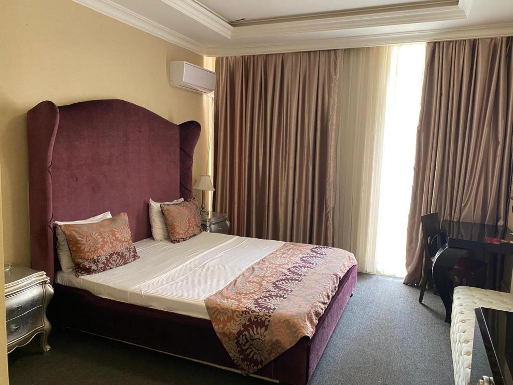 a bedroom with a large bed with a large window at Lake view Palace Hotel in Baku