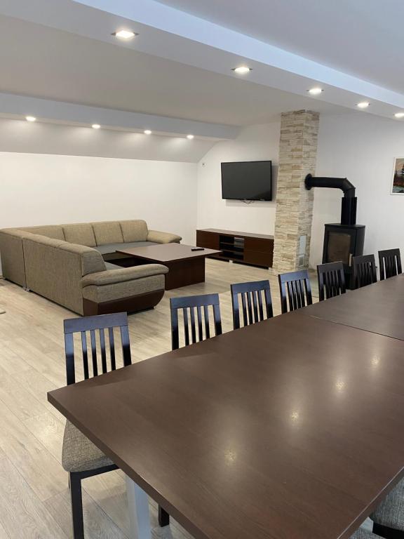 ein Wohnzimmer mit Tisch und Stühlen und einer Couch in der Unterkunft Chalupa GABO in Otilia