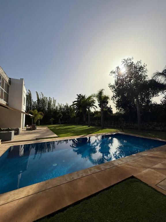 a swimming pool in front of a house at Villa 9- luxurious 5 bedrooms villa in the heart of Ambassadors in Rabat