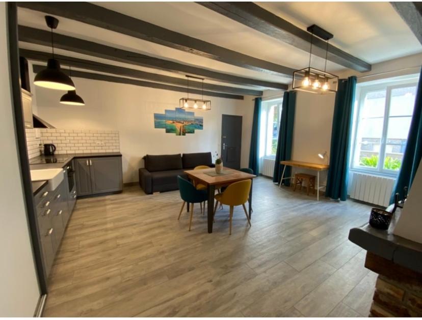 een keuken en een woonkamer met een tafel en stoelen bij residence fleurie rdc in Saint-Malo