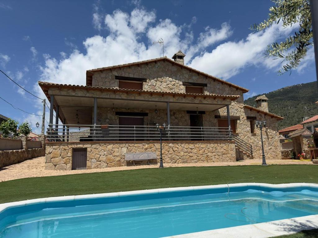 a house with a swimming pool in front of it at Los Olivos de José in El Barraco