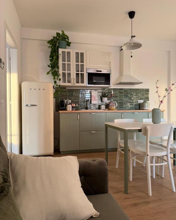 a kitchen with a white refrigerator and a table at Il Gelsomino in Crema