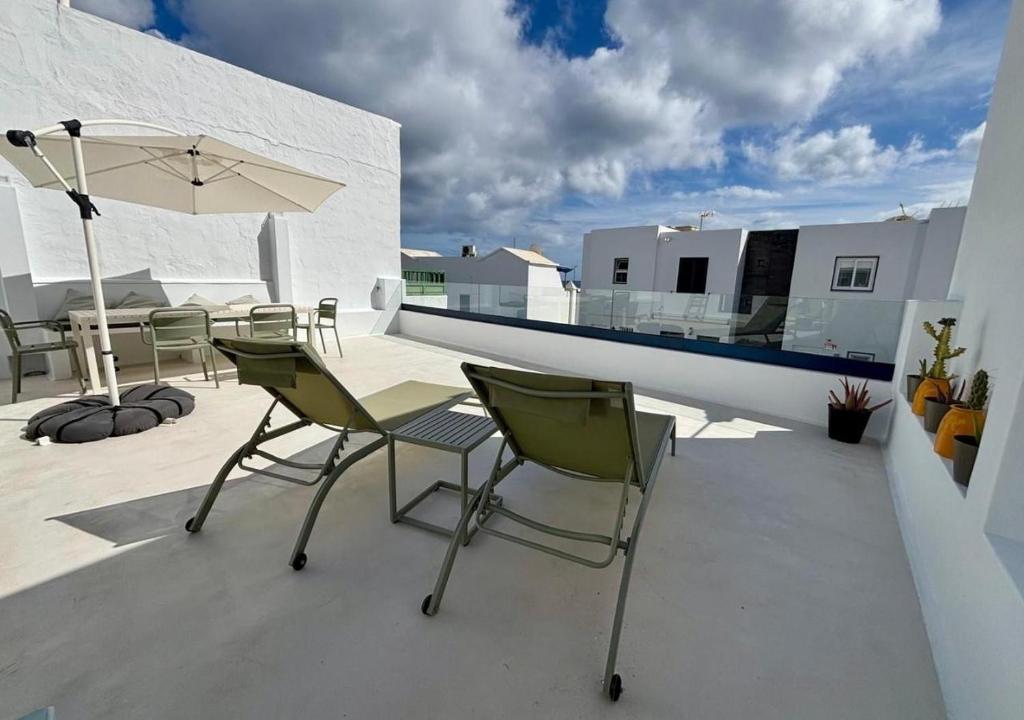 a patio with chairs and a table and an umbrella at casamujeres in Punta de Mujeres