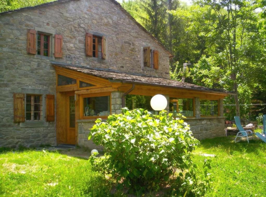 an old stone house in the middle of a yard at Il Seccatoio in Riolunato