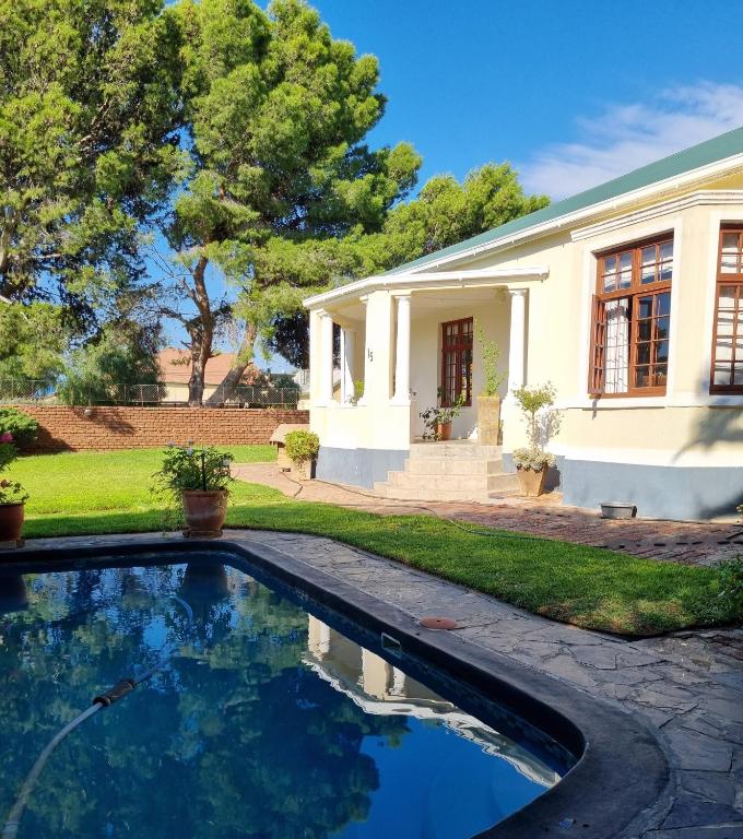 a house with a swimming pool in front of a house at Serene Haven Guest House in Victoria West