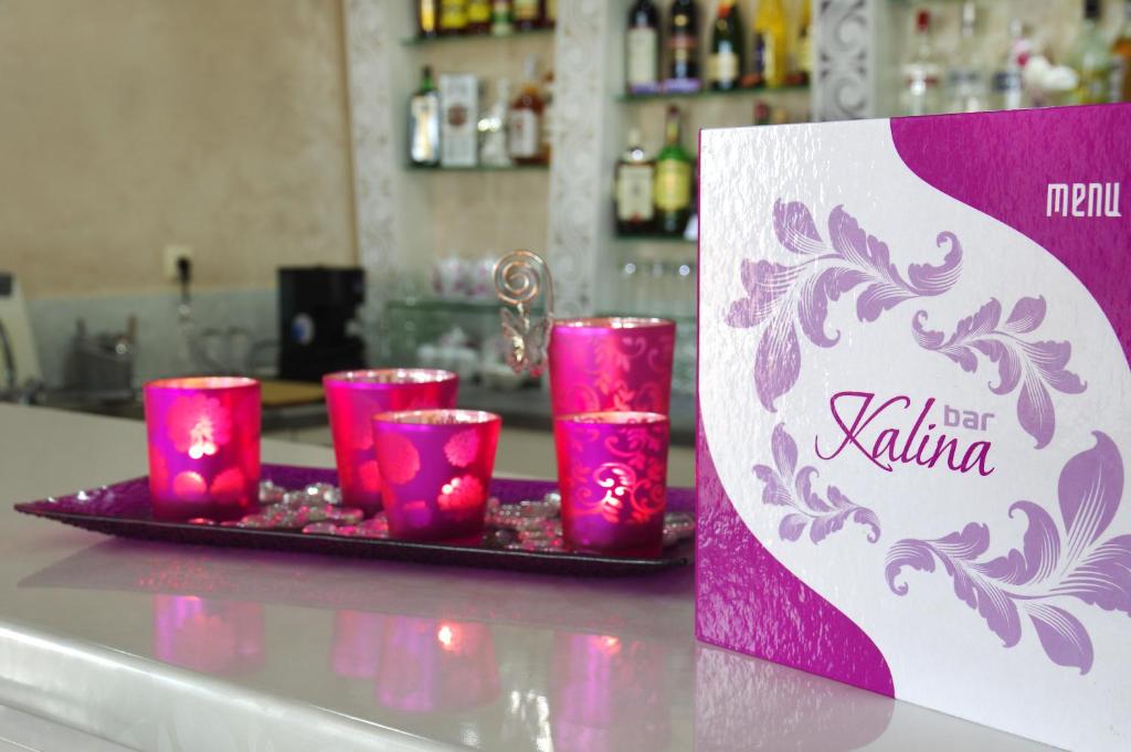 a tray of pink candles on a counter with a sign at Kalina Family Hotel in Burgas City