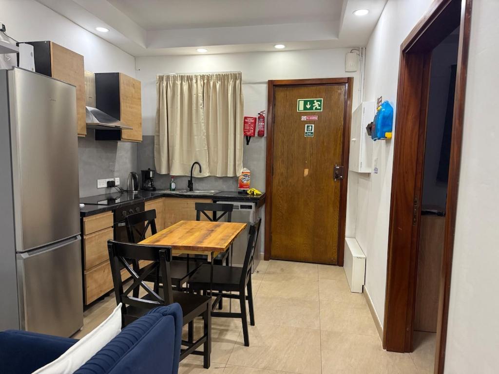 a kitchen with a table and chairs and a refrigerator at 4 Bed Maisonette Close to Mater Dei in Birkirkara