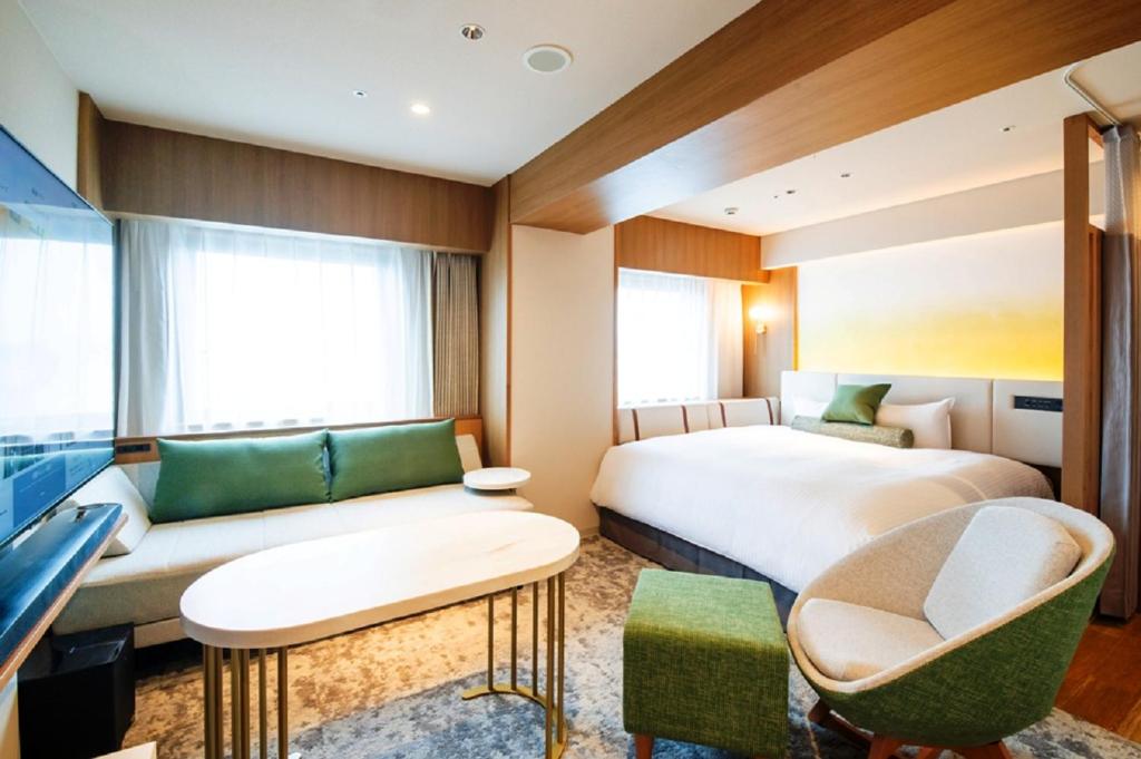 a hotel room with a bed and a couch at Richmond Hotel Miyazakiekimae in Miyazaki