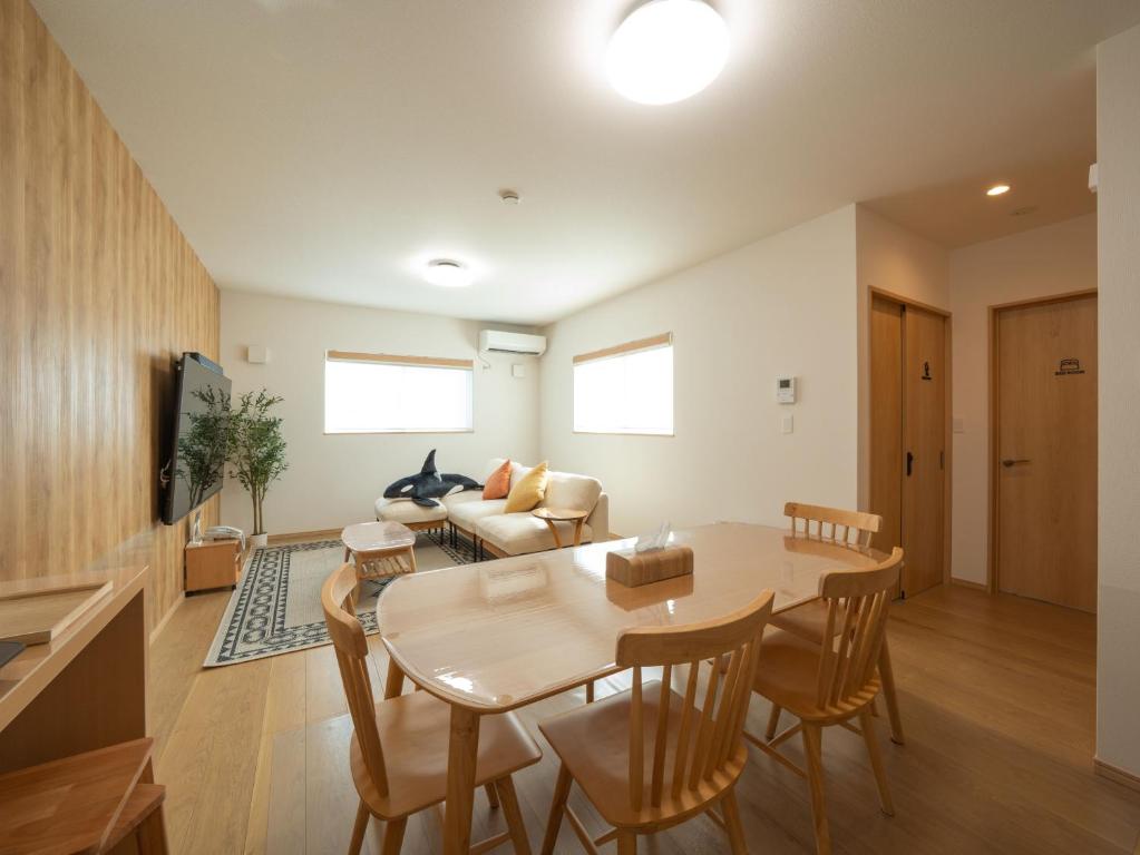 un soggiorno con un tavolo e un divano di Stationvilla-Nagoyaport a Nagoya