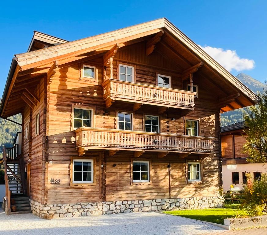 a log cabin with a balcony on top of it at Lodge Rose's Heart in Bramberg am Wildkogel