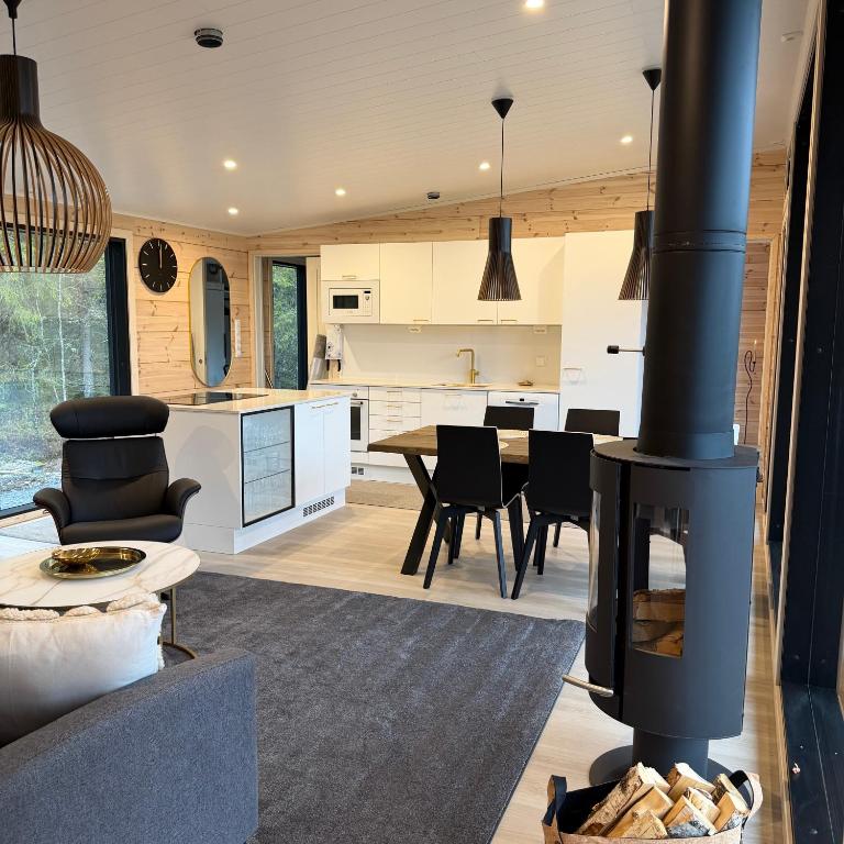 a kitchen and living room with a wood stove at Modern VillaJoenhelmi with jacuzzi and sauna in Kuusamo