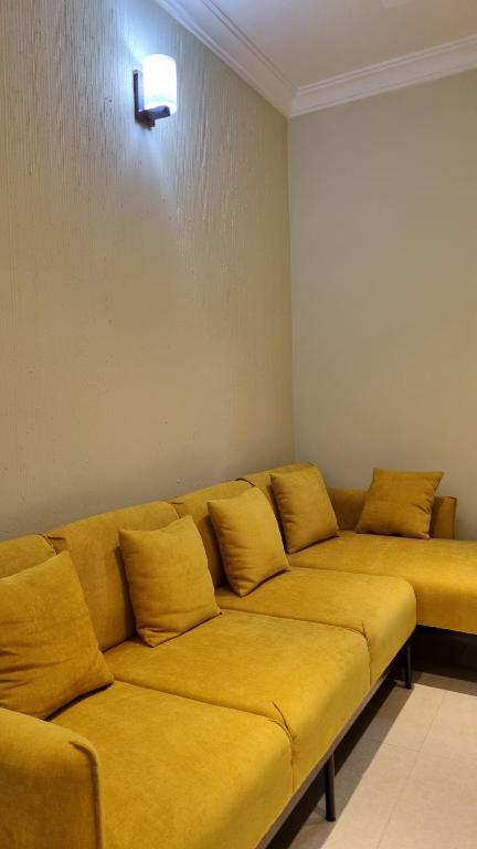 un divano con cuscini gialli in una stanza di Royal Crest a Dhaka