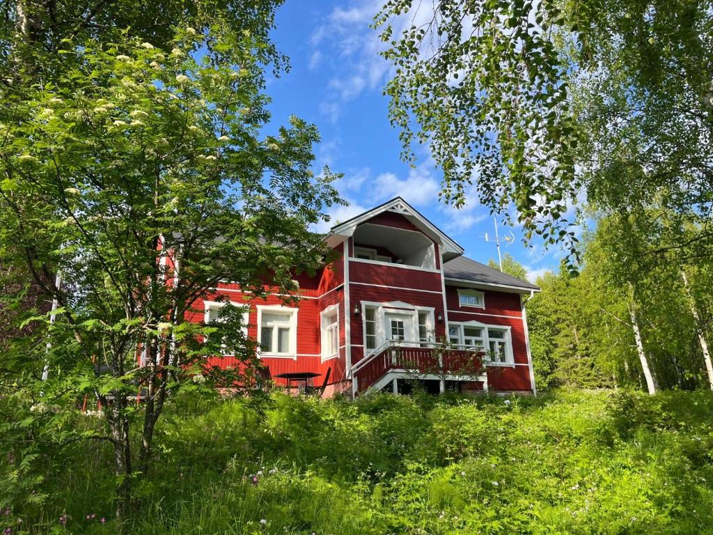 een rood huis op de top van een heuvel met bomen bij Lapland Dream Destinations in Rovaniemi