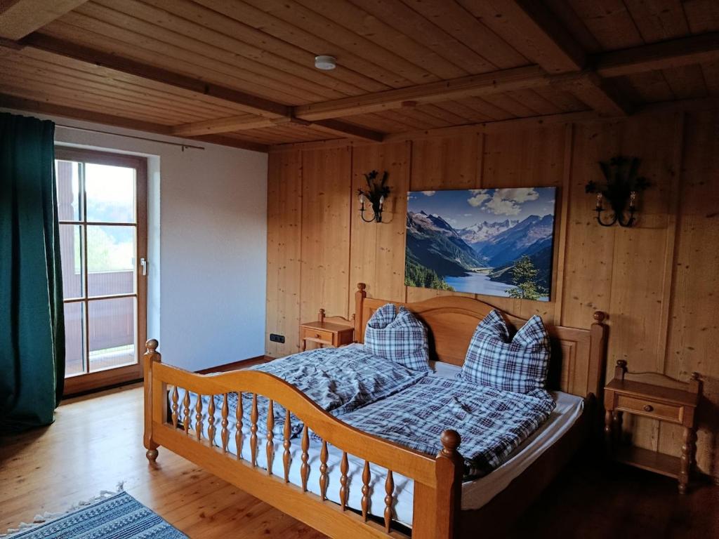 a bedroom with a bed with a picture on the wall at Idyllische Maisonettewohnung mit Bergblick in Irschenberg