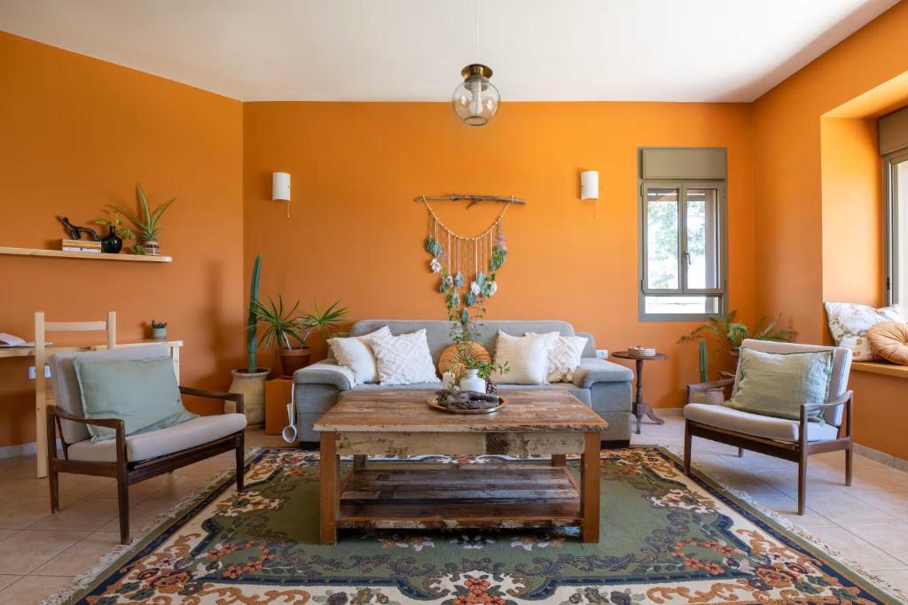 a living room with a couch and a table and chairs at Galilee sea View with Heated Pool in Arbel