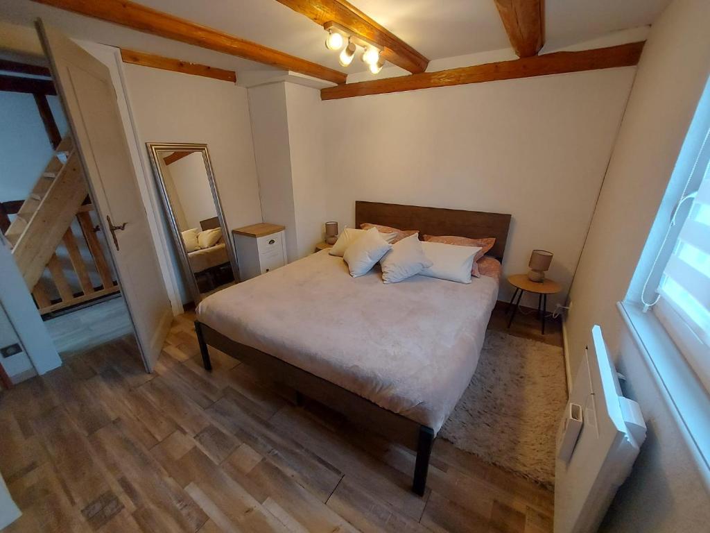 a bedroom with a bed in a room with wooden floors at La Maison Kouglof in Nordheim