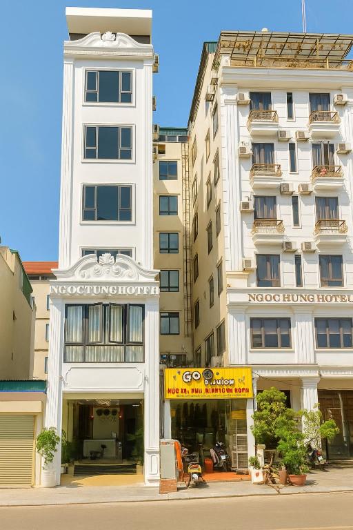 a tall white building on a city street at Ngọc Tùng Hotel in Ha Long