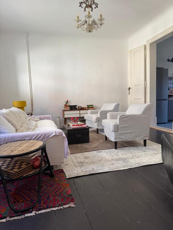 a living room with two white chairs and a bed at Südfrankreich bei Berlin in Werder