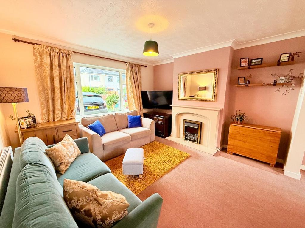 Una sala de estar con un sofá y una chimenea. en A Perfect Work Base & Family House in Fishpoads, en Bristol