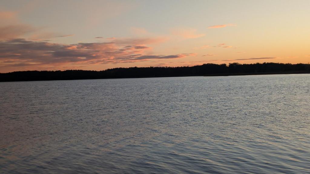 a sunset over a large body of water at Domek Letniskowy Zefirek in Nowy Dwór
