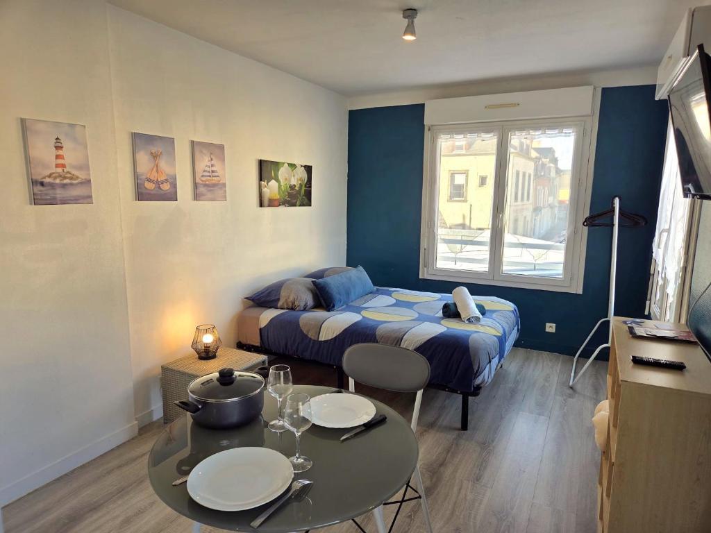 a room with a bed and a table with plates on it at Le Mat studio étoilé in Saint-Méloir-des-Ondes