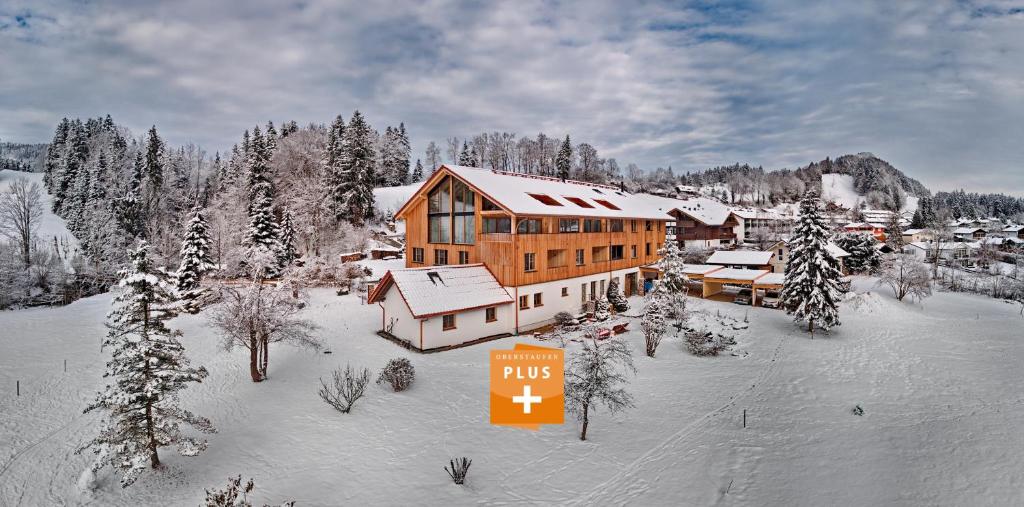 een skihut met een plusteken in de sneeuw bij Eibele Chalets in Oberstaufen