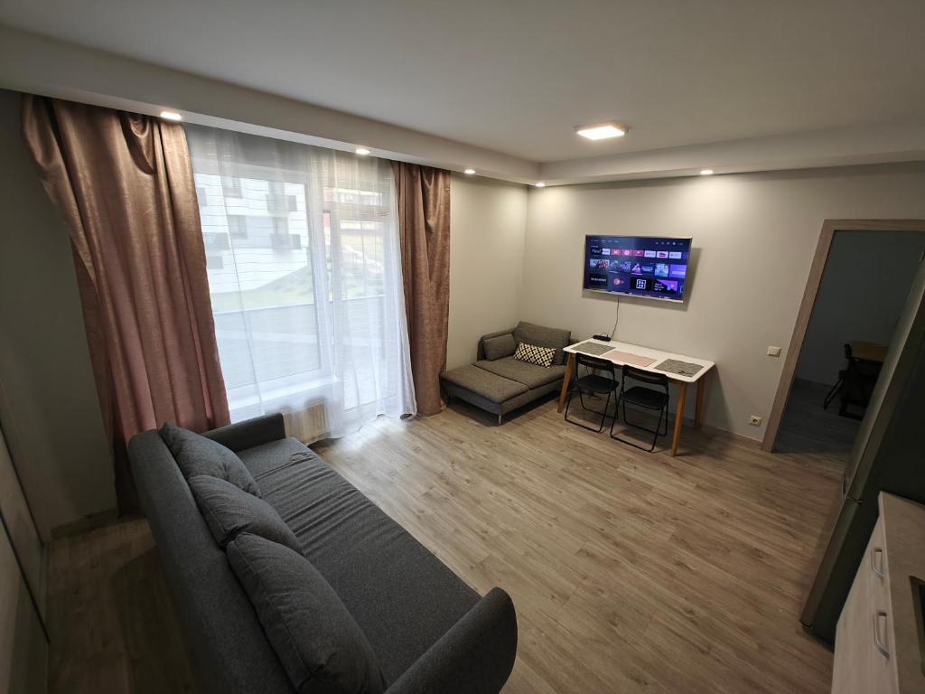 a living room with a couch and a table and a tv at Kavoliuko 14 in Vilnius