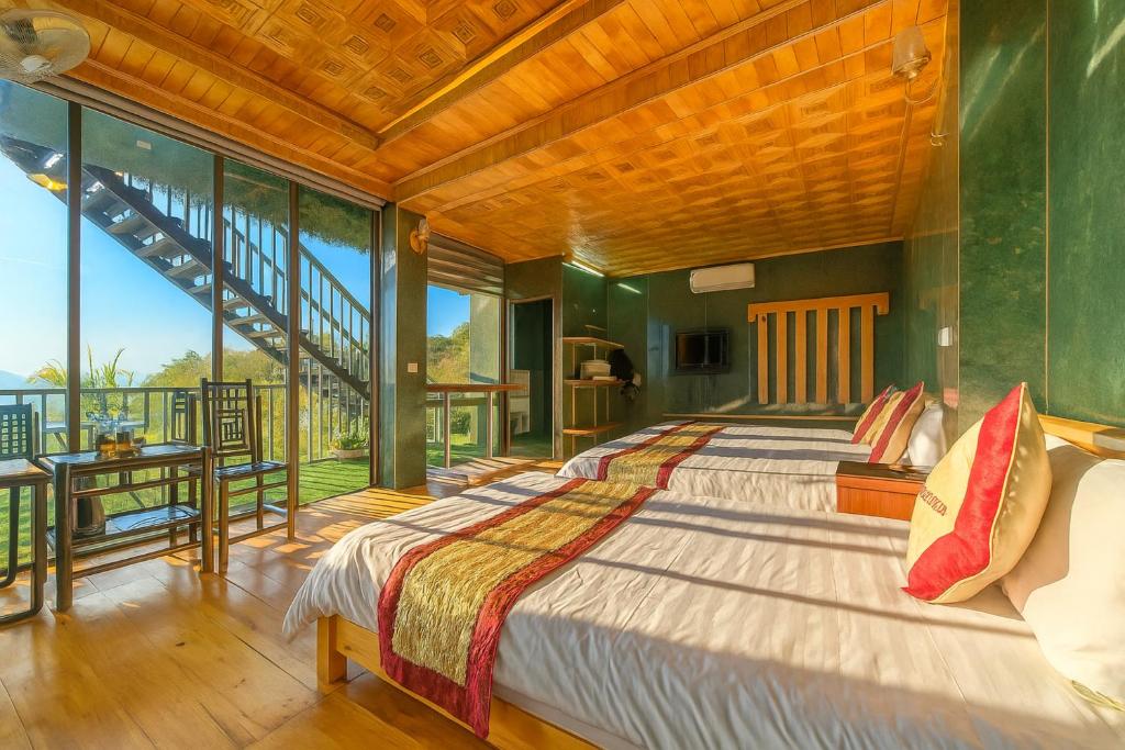 a bedroom with two beds and a large window at Hoàng Hà Hotel Tam Đảo in Tam Ðảo