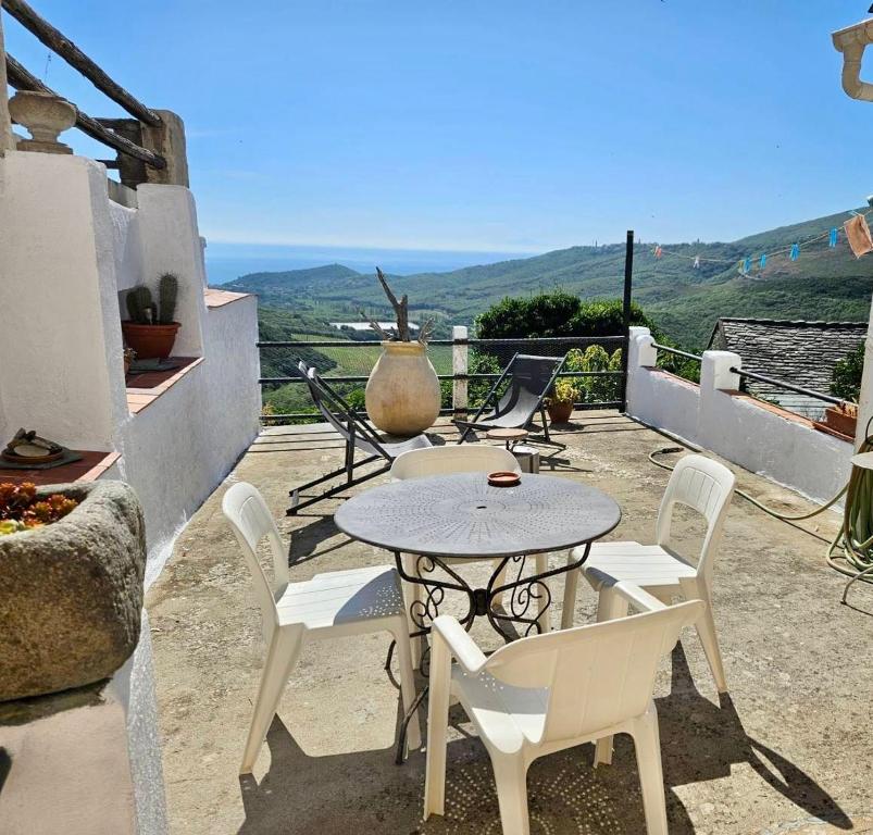a table and chairs on a patio with a view at Maison de charme avec Terrasse vue sur mer in Rogliano