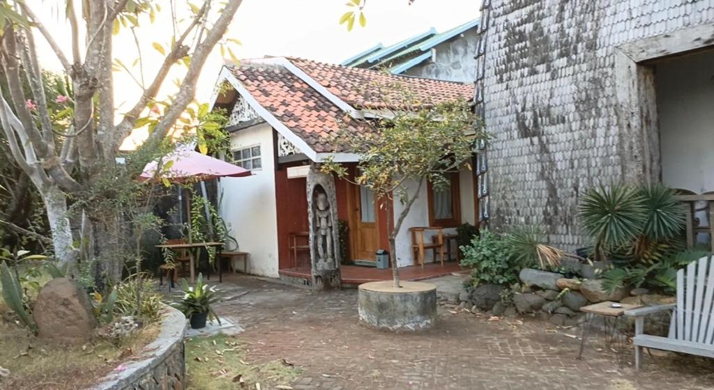 ein kleines weißes Haus mit einer roten Tür in der Unterkunft Chody House in Jepara