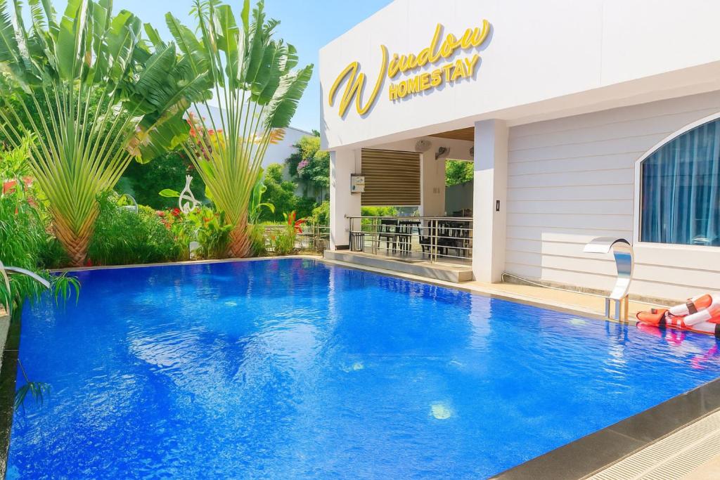 a large blue swimming pool next to a building at Window Homestay in Kon Tum
