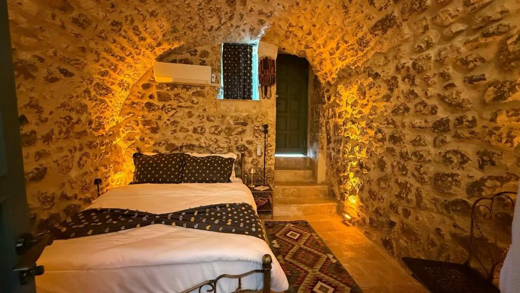 a bedroom with two beds in a stone wall at Liora Hotel in Sanlıurfa