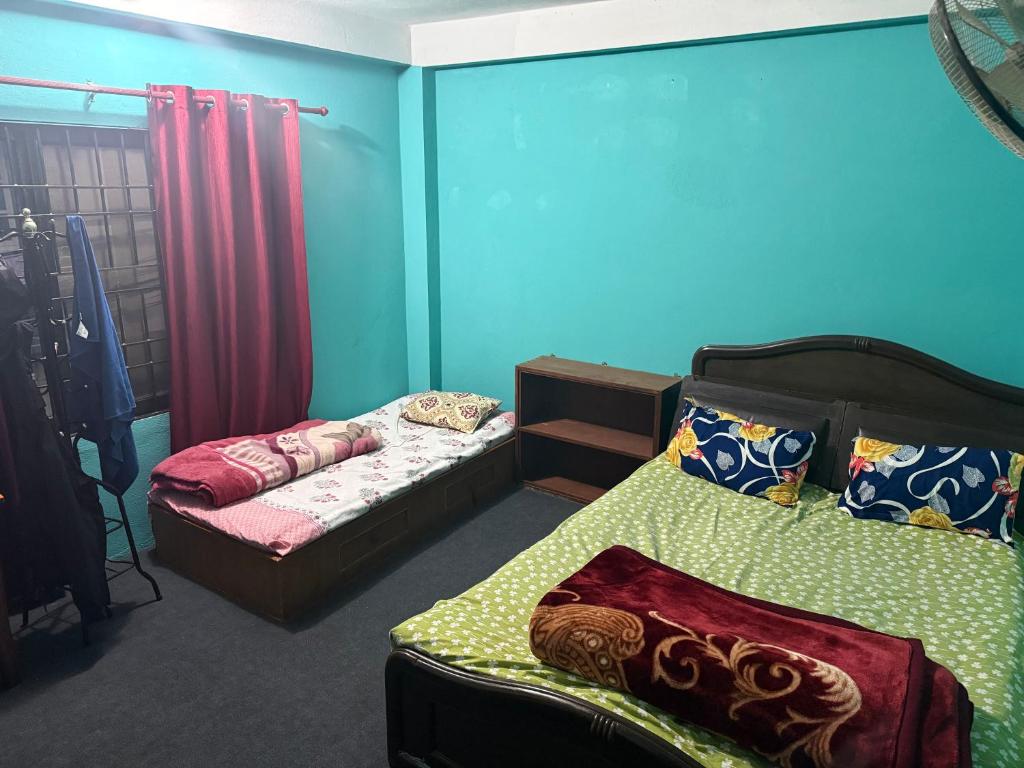 two beds in a room with blue walls at The Kapil Homestay in Manamaiju