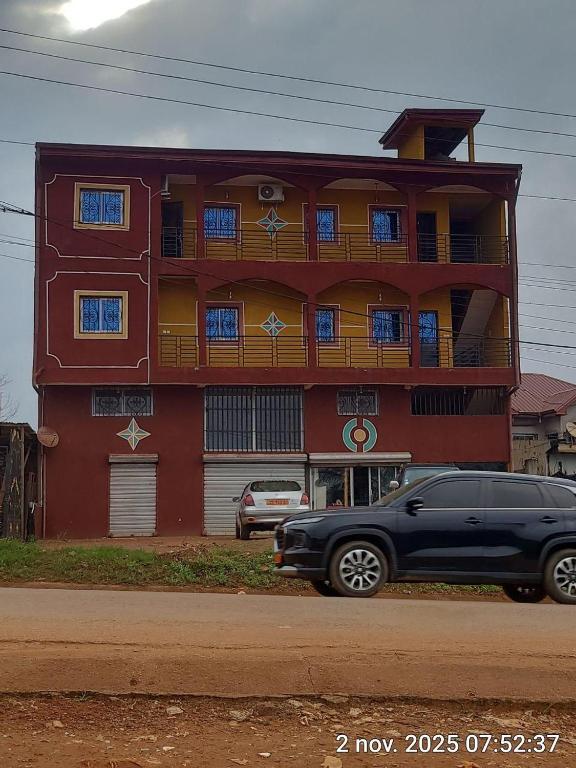 a black car parked in front of a red building at Euro Modern Studios Nkoabang-Yaounde in Yaoundé