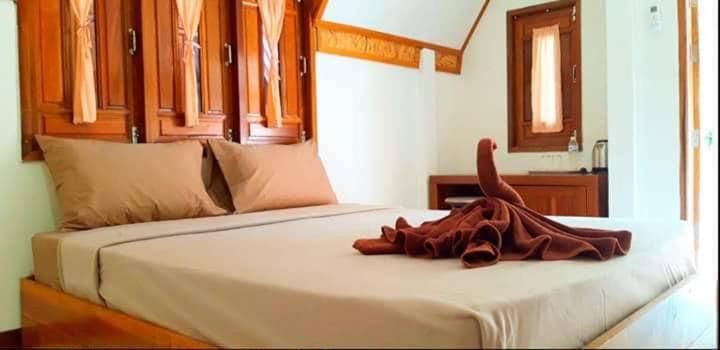 Una cama con una manta encima. en Koh Libong Maldives Homestay, 