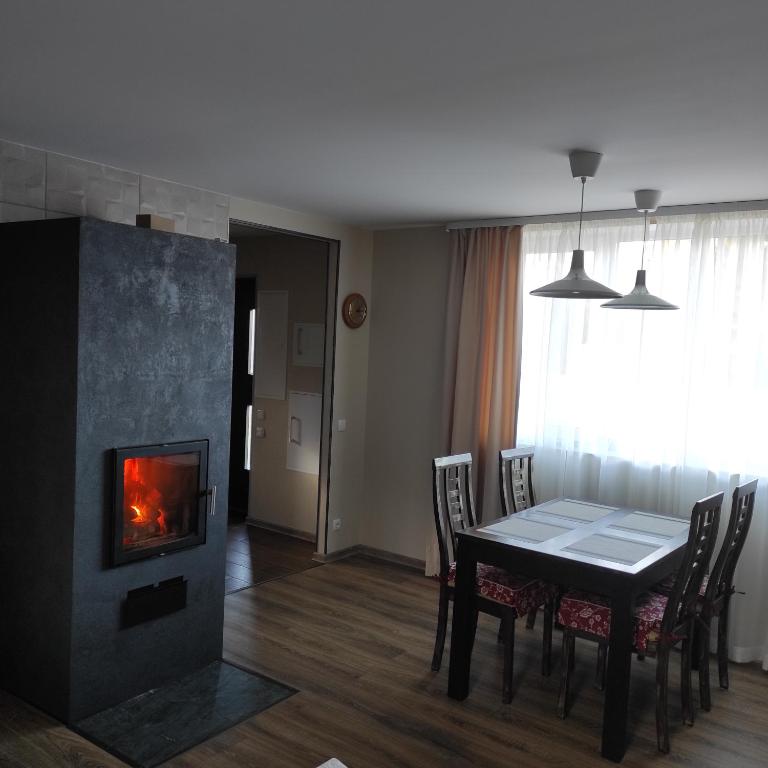 a dining room with a table and a fireplace at Tammiste Holiday House in Tammiste