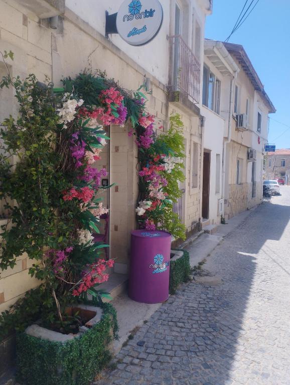 a building with flowers on the side of a street at noonbir Alaçatı otel in Alacati