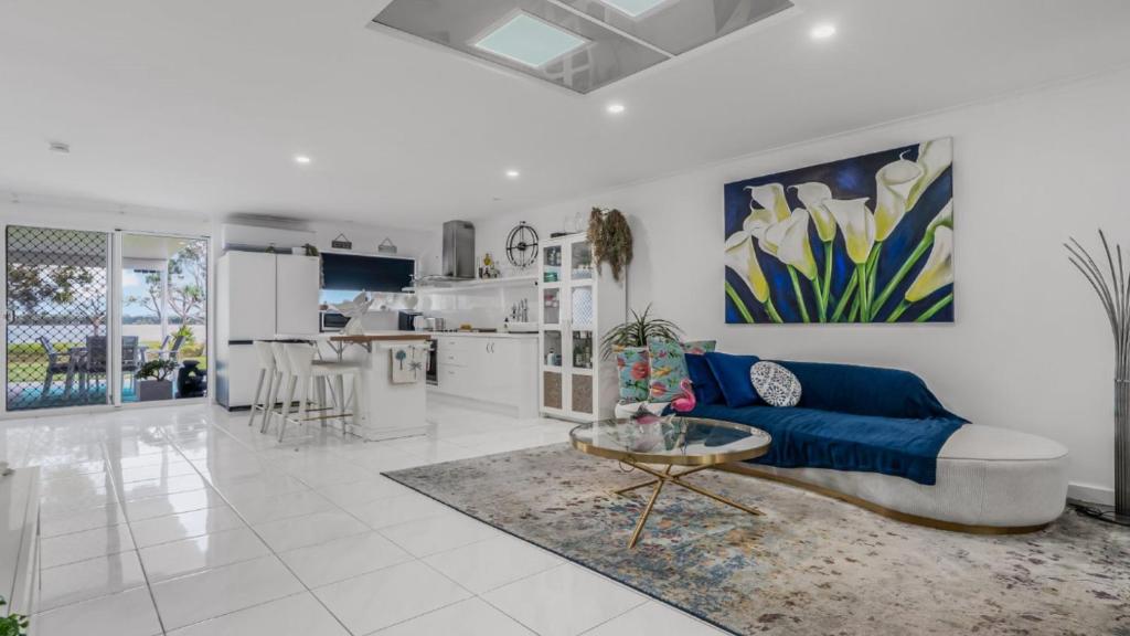 a living room with a blue couch and a table at The Luxe Waterfront in Sandstone Point