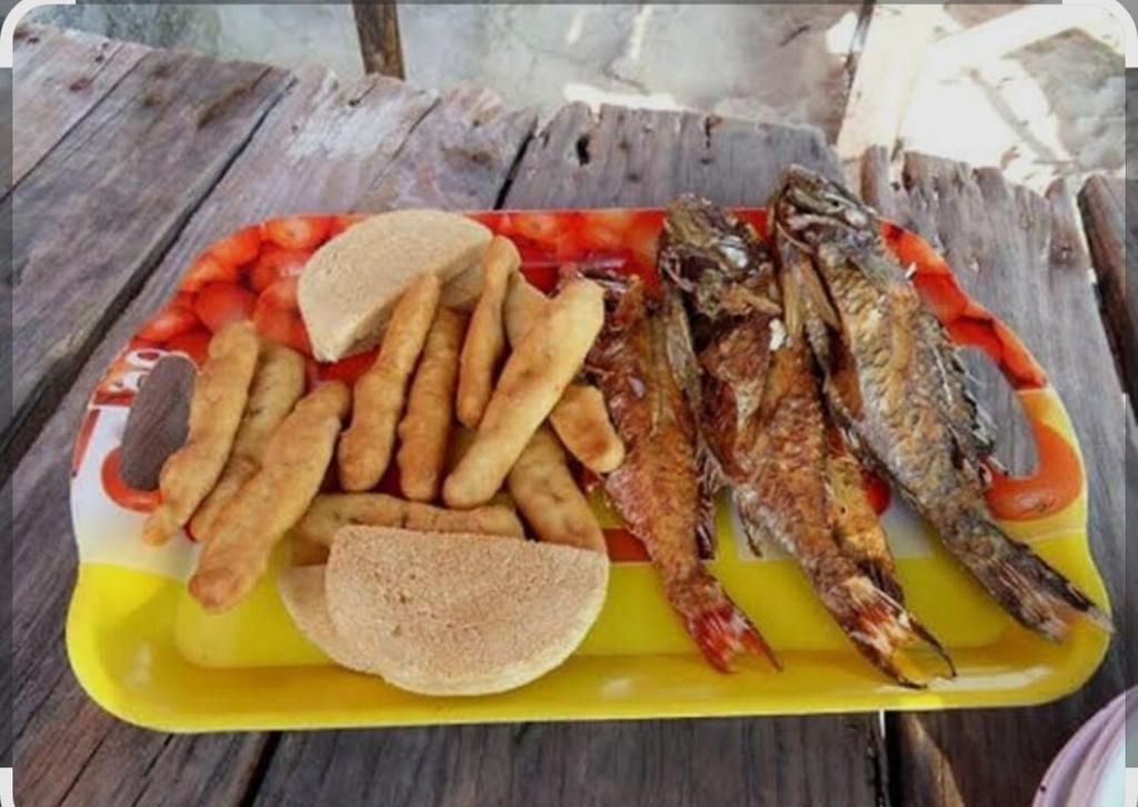 a yellow plate of food with fish and french fries at Suite Serene At Phoenix Park Village 1 in Portmore
