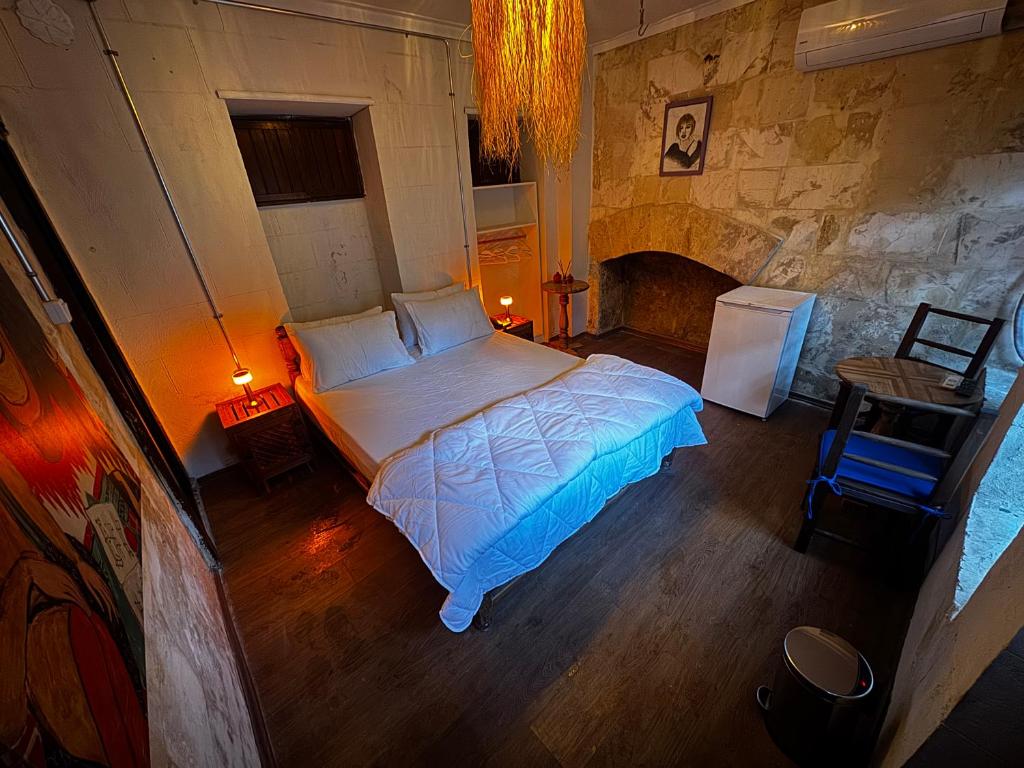 a bedroom with a bed in a room with a fireplace at Otel Mahlas in Şahinbey