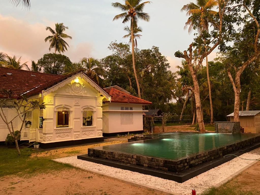 a house with a swimming pool in front of a house at Casa Del Ceylon in Hikkaduwa
